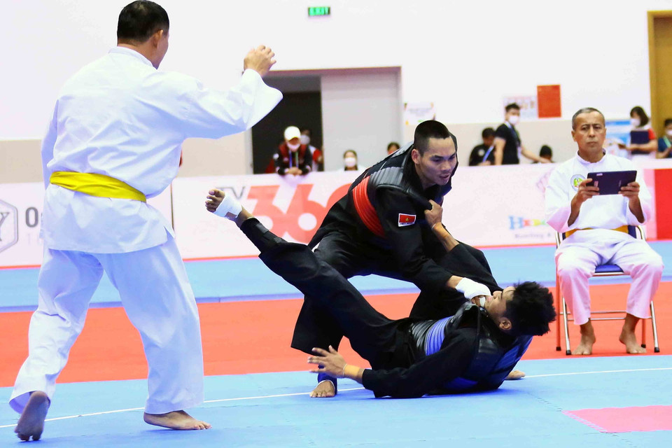 Pha đánh ngã đối phương ghi 3 điểm của vận động viên Trần Đình Nam (Việt Nam-đỏ). (Ảnh: Quang Quyết/TTXVN)