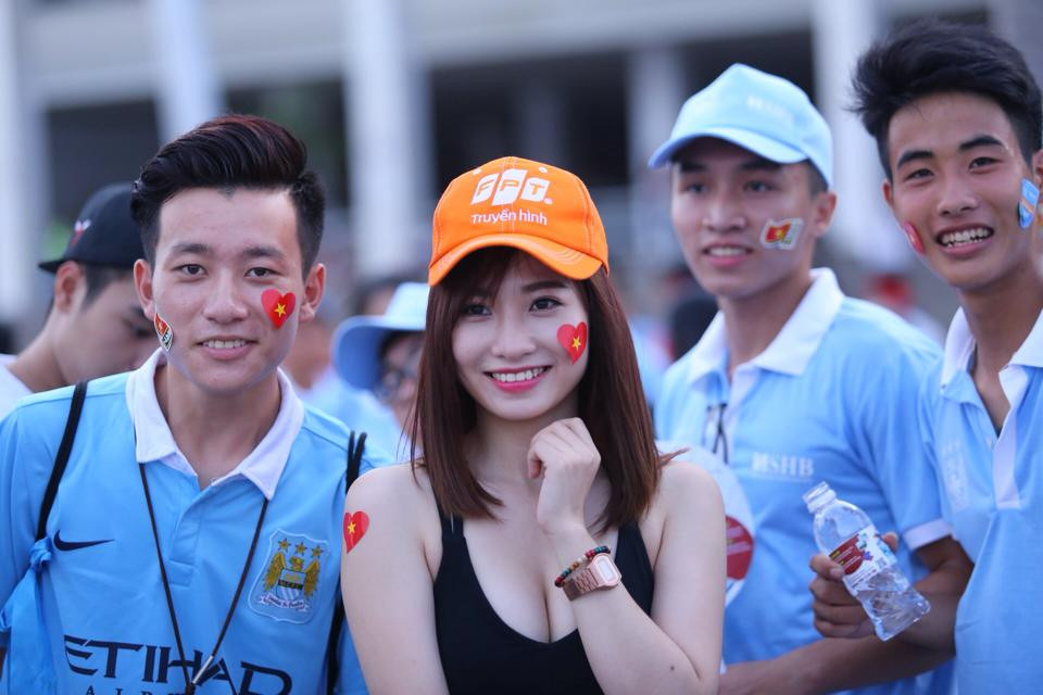 Một người đẹp chụp ảnh cùng các fan Manchester City. (Ảnh: Minh Chiến/Vietnam+)