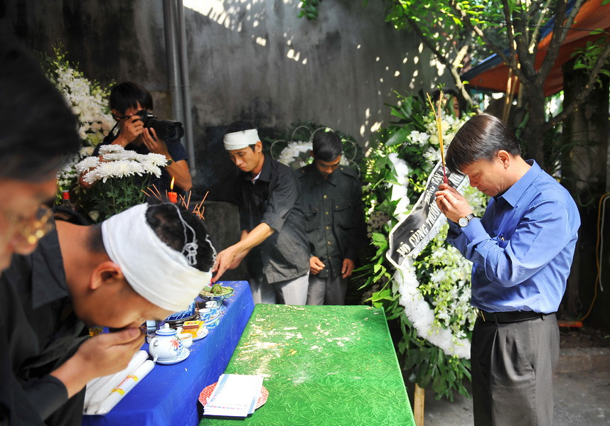 Đồng chí Nguyễn Đức Lợi, Ủy viên Trung ương Đảng, Bí thư Đảng ủy, Tổng Giám đốc Thông tấn xã Việt Nam thắp hương, viếng và chia buồn cùng gia đình phóng viên Đinh Hữu Dư. (Ảnh: Minh Đức/TTXVN)