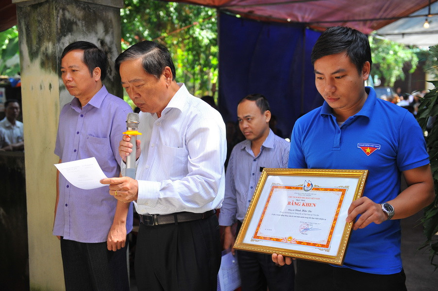 Đọc quyết định truy tặng Bằng khen của Hội Nhà báo Việt Nam cho đồng chí Đinh Hữu Dư. (Ảnh: Minh Đức​/TTXVN)