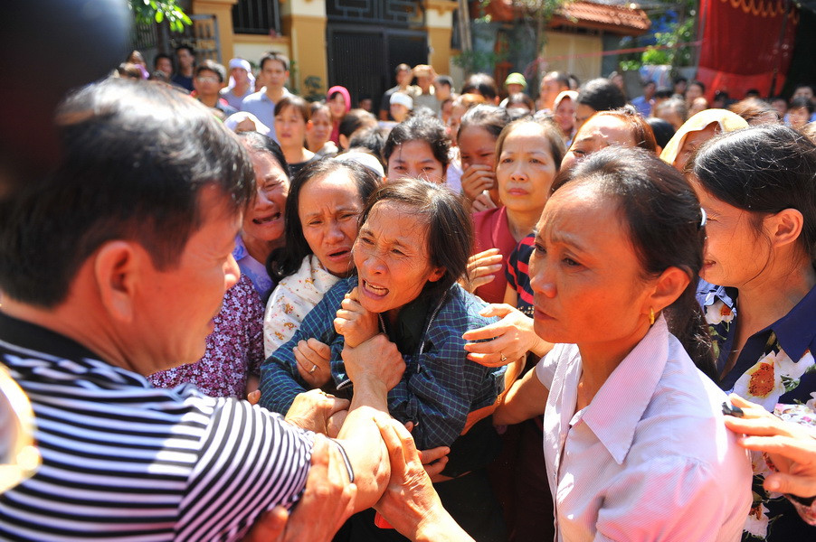 Hình ảnh xúc động của mẹ phóng viên Đinh Hữu Dư và người thân trong giờ phút tiễn đưa con. (Ảnh: Ninh Đức /TTXVN​)