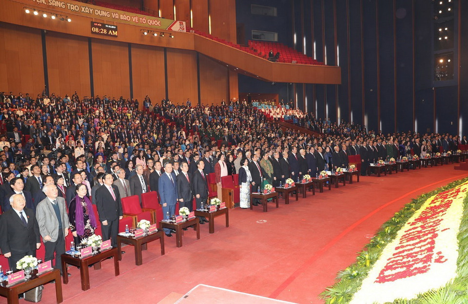 Các lãnh đạo Đảng, Nhà nước và các đại biểu thực hiện nghi lễ chào cờ tại Đại hội. (Ảnh: TTXVN)