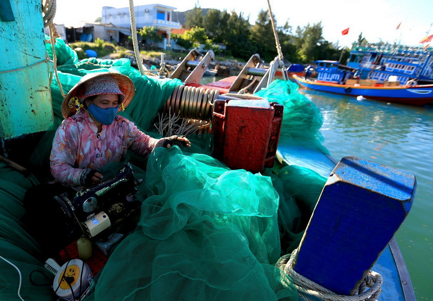 Người dân trên đảo dùng thiết bị điện để may lưới, chế tạo ngư cụ. (Ảnh: Ngọc Hà/TTXVN)