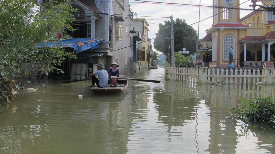 Người dân thôn Kênh Gà chèo thuyền để đi lại. (Ảnh: Thùy Dung/TTXVN)