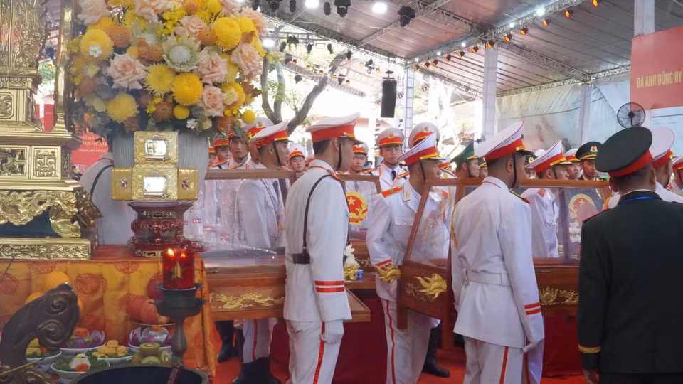 Hài cốt liệt sĩ được phủ cờ Tổ quốc trang trọng trước khi truy điệu. (Ảnh: PV/Vietnam+)