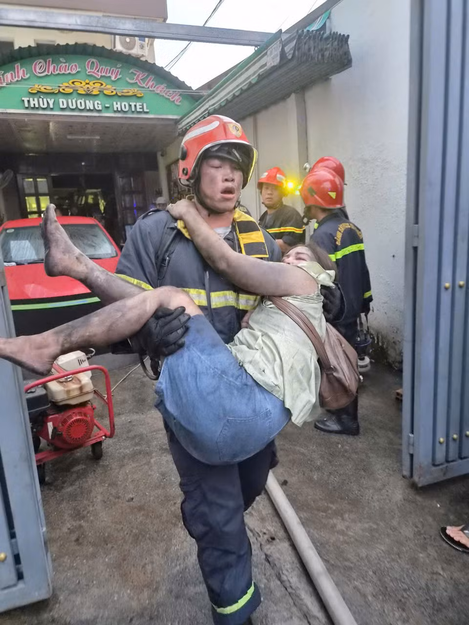 Một chiến sỹ Phòng cháy chữa cháy và Cứu nạn cứu bế một nạn nhân nữ đang bị ngạt khói từ tầng 4 xuống dưới đất. (Ảnh: CTV/Vietnam+)