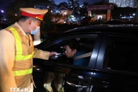 Lực lượng Cảnh sát Giao thông kiểm tra nồng độ cồn với các chủ phương tiện tham gia giao thông. (Ảnh: Phạm Kiên/TTXVN)