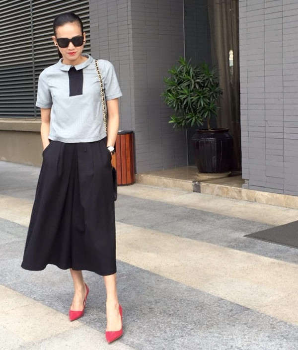 Dương Mỹ Linh chọn giày cao gót đỏ làm chi tiết cuốn hút, giúp bộ cánh tông màu trầm thêm nổi bật.