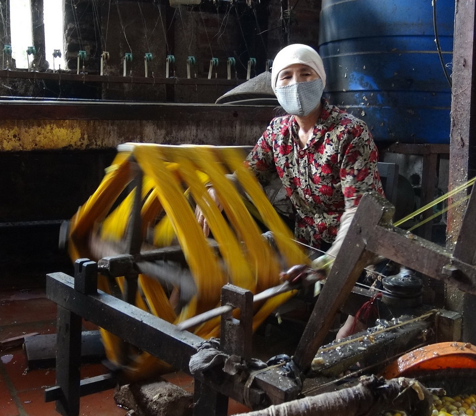 Để có thể tạo nên những sợi tơ đều và óng, người quay phải đều tay, kéo tơ giỏi. (Ảnh: Thanh Thương/TTXVN)