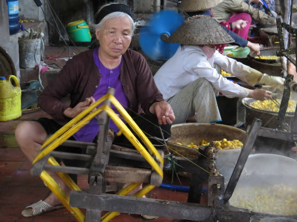 Cụ Chu Thị Thư (74 tuổi) vẫn ngày ngày quay tơ với mong muốn một ngày làng nghề được khôi phục lại như thời kỳ phát triển thịnh hành. (Ảnh: Thanh Thương/TTXVN)
