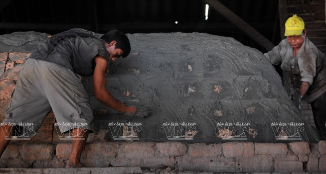 Những người thợ trát kín lò trước khi nung.