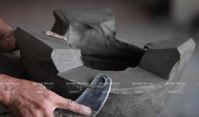 Cẩn thận gọt bỏ những chỗ thừa để hoàn chỉnh một chiếc lò đất.