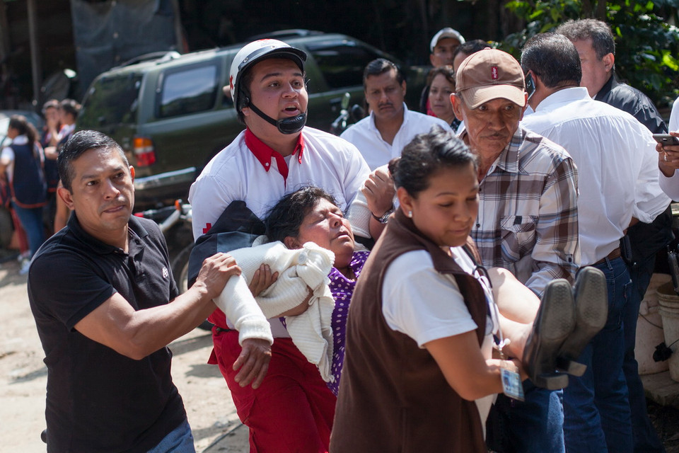 Lực lượng cứu hộ chuyển người bị thương sau vụ lở đất tại làng El Cambray ngày 2/10. (THX/ TTXVN)