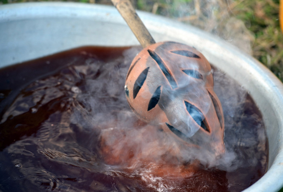 Gốm sau khi nung được nhúng hoặc phun nước để tạo mầu đen bóng cho sản phẩm.(Ảnh: Thanh Hà/TTXVN)