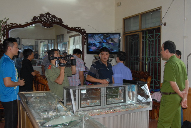 Các lực lượng chức năng khám nghiệm hiện trường vụ cướp. (Ảnh: Hoàng Nhương/TTXVN)