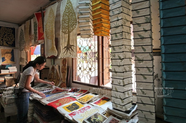 Du khách chọn mua sản phẩm từ giấy saa tại làng Xangkhongposa.