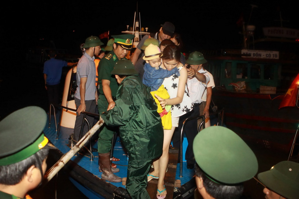 Khách mắc kẹt được tàu HQ634 vùng 1 Hải Quân bàn giao cho 3 tàu du lịch tại khu vực Cửa Đối để chở về đất liền. (Ảnh: Minh Quyết/TTXVN)