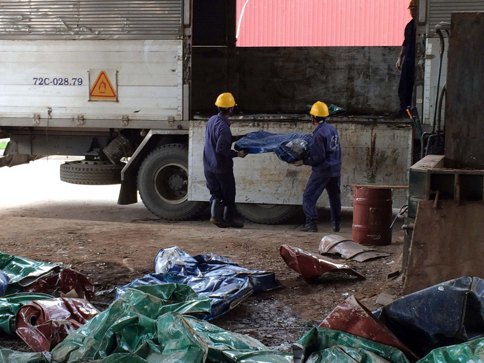 Lực lượng chức năng vận chuyển số thùng phuy còn lại đưa đi xử lý chất độc hại. (Ảnh: Đoàn Mạnh Dương /TTXVN)