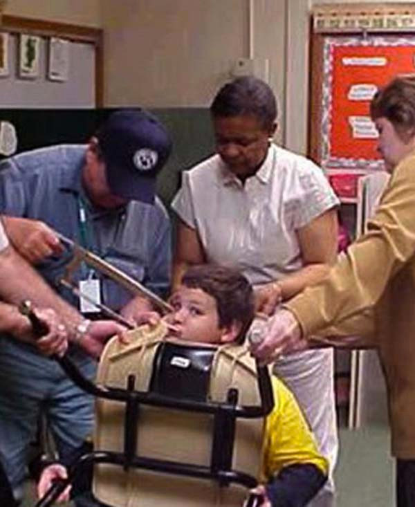 Trong khi đầu bị kẹt với chiếc ghế, cậu nhóc vẫn tiếp tục ngậm kẹo mút! (Ảnh: The Noob Dad)