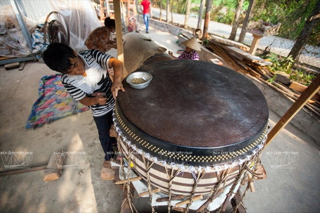 Công đoạn gắn da trâu vào tang trống để làm mặt. (Ảnh: Lê Minh)