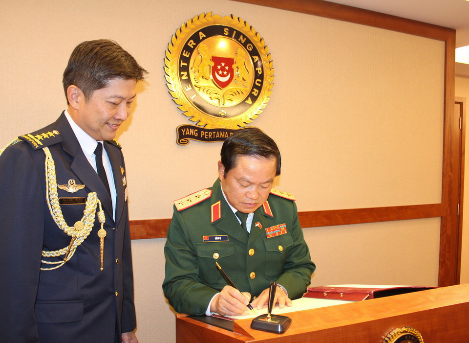 Thượng tướng Đỗ Bá Tỵ, Tổng Tham mưu trưởng, Thứ trưởng Bộ Quốc phòng Việt Nam ghi sổ lưu niệm tại Trụ sở Bộ Quốc phòng Singapore ngày 13/11/2014. (Ảnh: Lê Hải/TTXVN) 