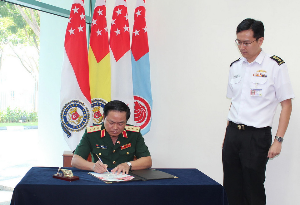 Thượng tướng Đỗ Bá Tỵ, Tổng Tham mưu trưởng Quân đội Nhân dân Việt Nam ghi sổ lưu niệm tại Trung tâm chia sẻ thông tin (IFC), Trung tâm chỉ huy kiểm soát (CC2C) tại căn cứ Hải Quân Singapore chiều ngày 13/11/2014. (Ảnh: Lê Hải/TTXVN)