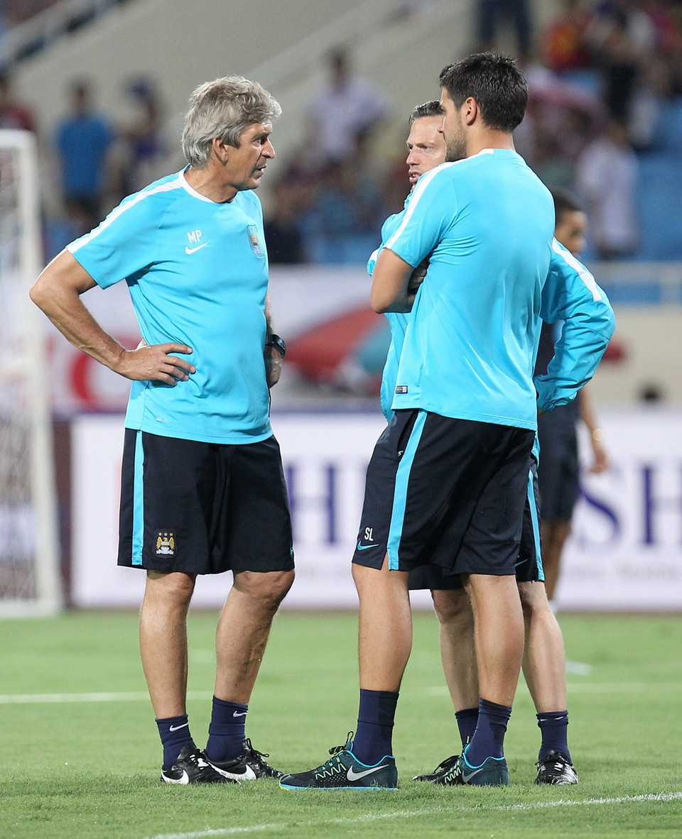 Ban huấn luyện CLB Manchester City trao đổi trong buổi tập trên sân Mỹ Đình tối 26/7. (Ảnh: Quốc Khánh/TTXVN) 