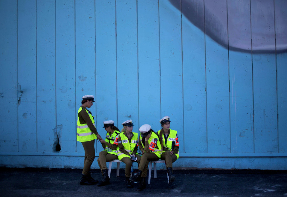 Nữ cảnh sát Israel chờ đợi buổi trưng bày tên lửa thu giữ được từ tàu chở hàng KLOS C mang cờ Panama bị chặn ngoài khơi bờ biển Sudan ngày 10/3. (Ảnh: AP)