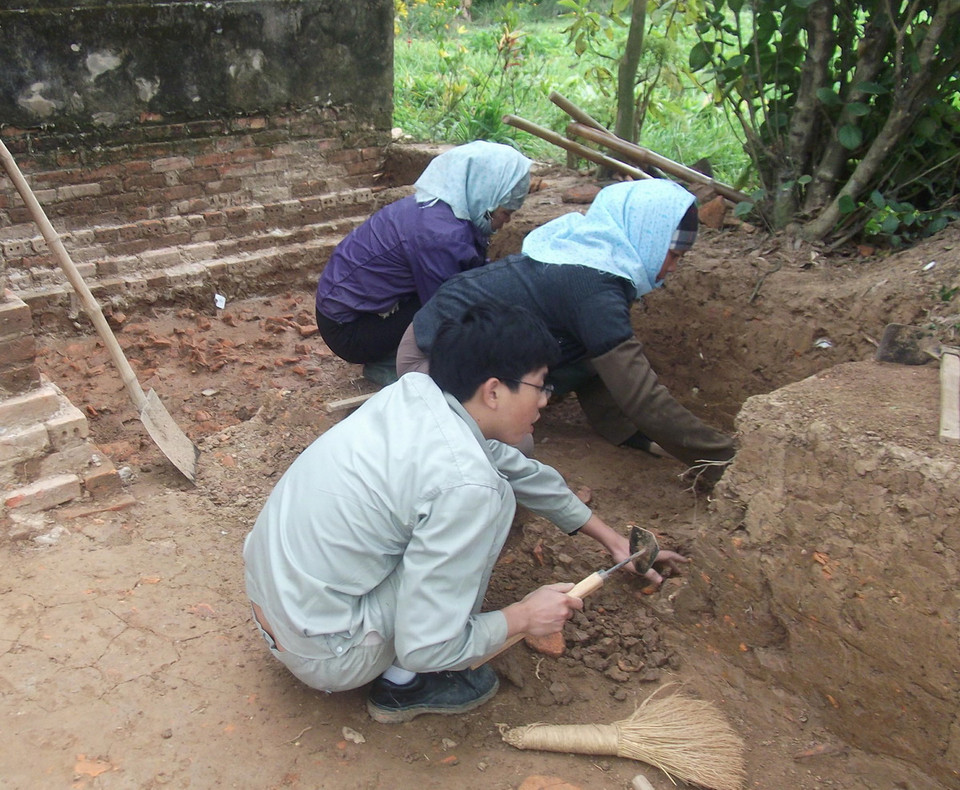 Khai quật, thu lượm hiện vật. (Ảnh: Thu Hoài/TTXVN)