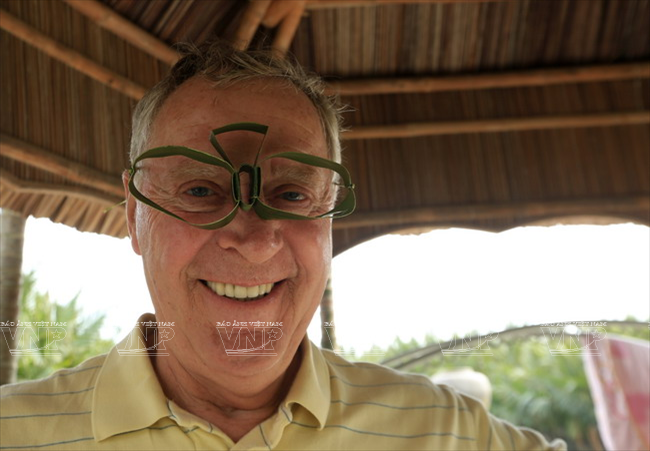 Du khách nước ngoài thích thú với những trò chơi dân gian được làm từ lá dừa nước của vùng Cẩm Thanh. (Ảnh: Thông Thiện)