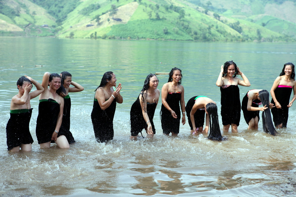 Phụ nữ Thái gội đầu trên Sông Đà. (Ảnh: Chính Tới)