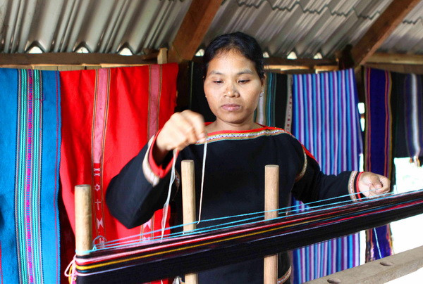 Xếp các sợi có mầu sắc khác nhau theo mẫu trước khi dệt. (Ảnh: Dương Giang/TTXVN)