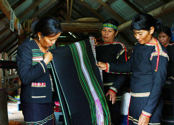 Chị H’Yam BKrông (bên trái), Chủ nhiệm hợp tác xã Tơng Bông kiểm tra sản phẩm. (Ảnh: Dương Giang/TTXVN)