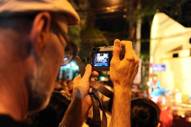 Du khách nước ngoài thích thú với việc ghi lại những khoảnh khắc trên phố cổ Hà Nội, khi không gian đi bộ tại đây được mở rộng. (Ảnh: Minh Đức)