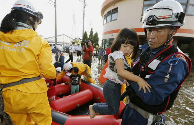  Nhân viên cứu hỏa sơ tán người dân khỏi các khu vực ngập lụt sau khi bão Phanfone tràn qua Tokyo. (ẢNh: Kyodo/TTXVN)