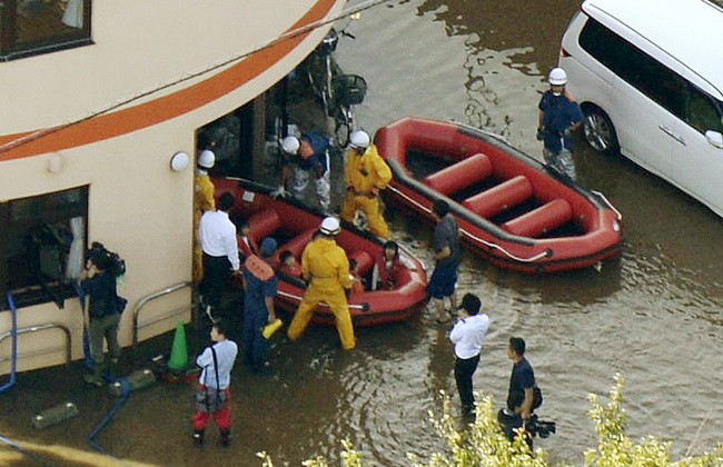 Nhân viên cứu hỏa sơ tán người dân khỏi các khu vực ngập lụt sau khi bão Phanfone tràn qua Tokyo. (Ảnh: Kyodo/TTXVN)