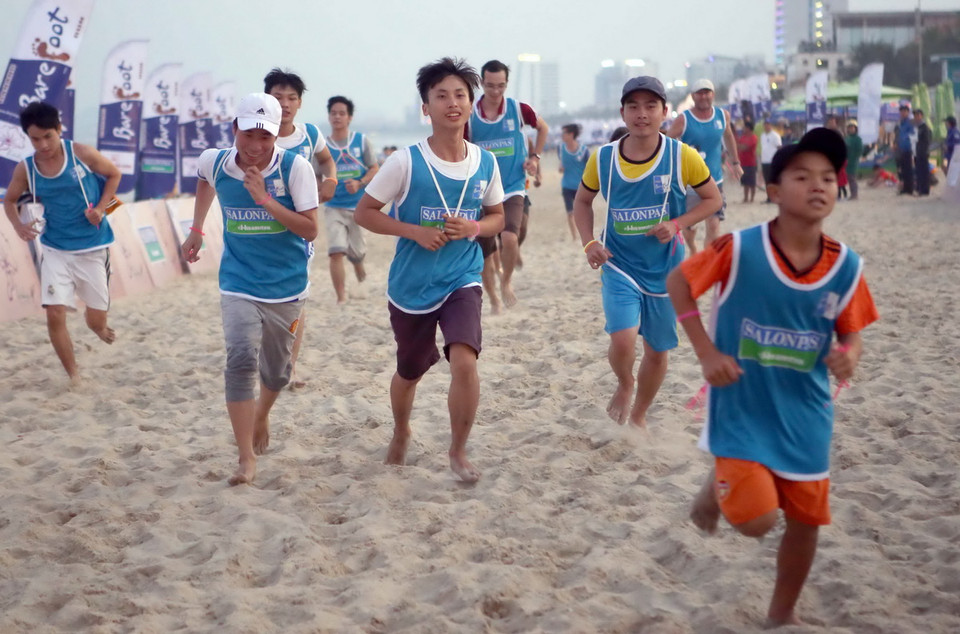 Các vận động viên tranh tài chạy chân trần 2 km trên biển Đà Nẵng. (Ảnh: Lê Lâm/TTXVN)