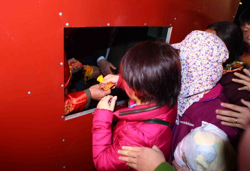 Du khách tham gia lễ phát lương tại đền Trần Thương. (Ảnh: TTXVN)