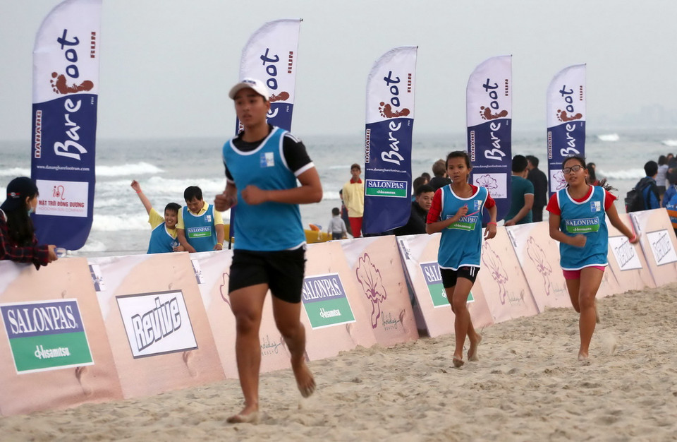  Các vận động viên tranh tài chạy chân trần ở cự ly 10km trên biển Đà Nẵng.(Ảnh: Lê Lâm/TTXVN)
