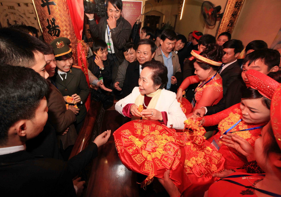  Phó Chủ tịch nước Nguyễn Thị Doan phát lương cho nhân dân tại đền Trần Thương. (Ảnh: TTXVN)