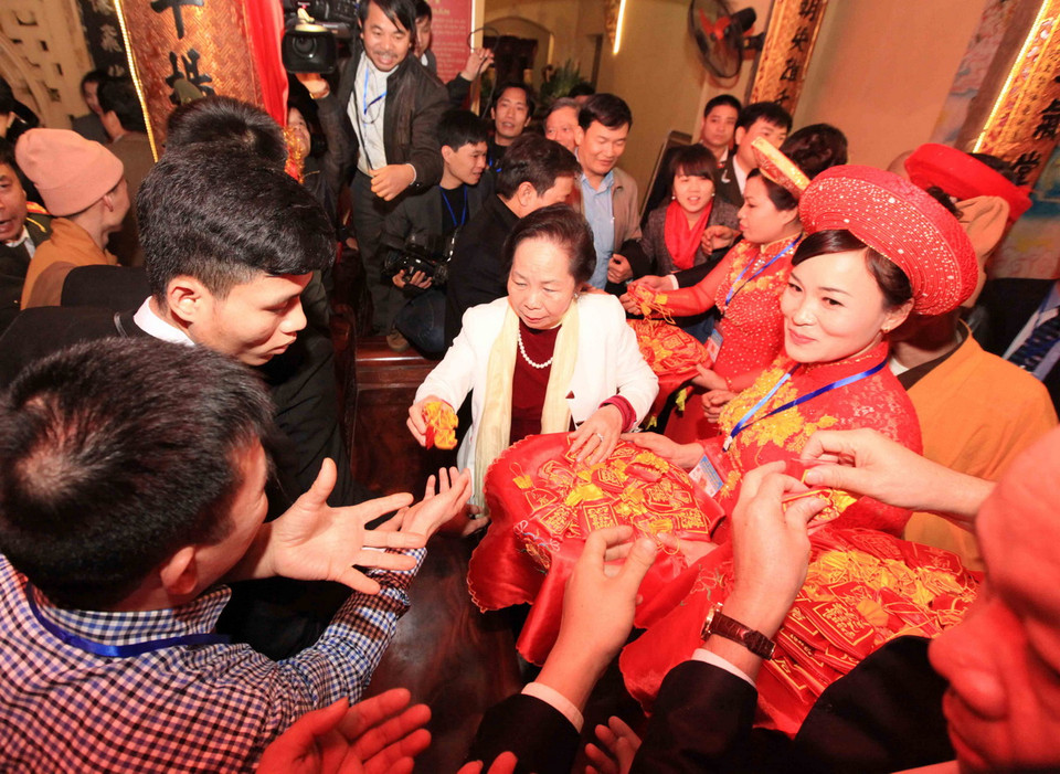  Phó Chủ tịch nước Nguyễn Thị Doan phát lương cho nhân dân tại đền Trần Thương. (Ảnh: TTXVN)