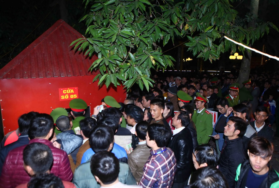 Du khách tham gia lễ phát lương tại đền Trần Thương. (Ảnh: TTXVN)