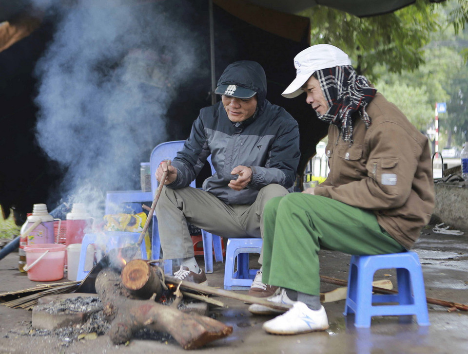 Người dân Hà Nội đốt củi sưởi ấm ngay trên vỉa hè. Ảnh: (Hà My/TTXVN)