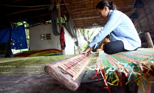 Đôi bàn tay thoăn thoắt chuồi, sắp xếp từng sợi lác theo từng màu vào go khi dệt chiếu.