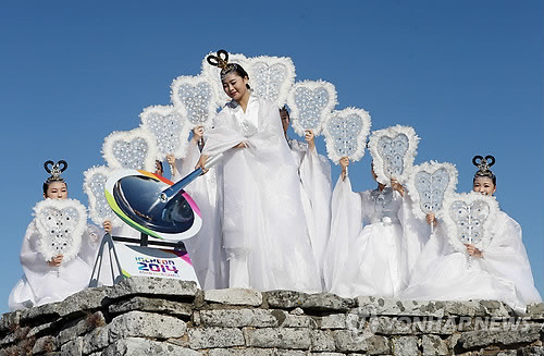 Các thiếu nữ trong trang phục tiên nữ giáng trần thực hiện nghi thức lấy lửa. (Ảnh: Yonhap News)