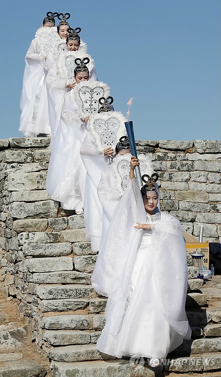 Các thiếu nữ trong trang phục tiên nữ giáng trần thực hiện nghi thức lấy lửa. (Ảnh: Yonhap News)