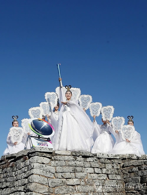 Các thiếu nữ trong trang phục tiên nữ giáng trần thực hiện nghi thức lấy lửa. (Ảnh: Yonhap News)