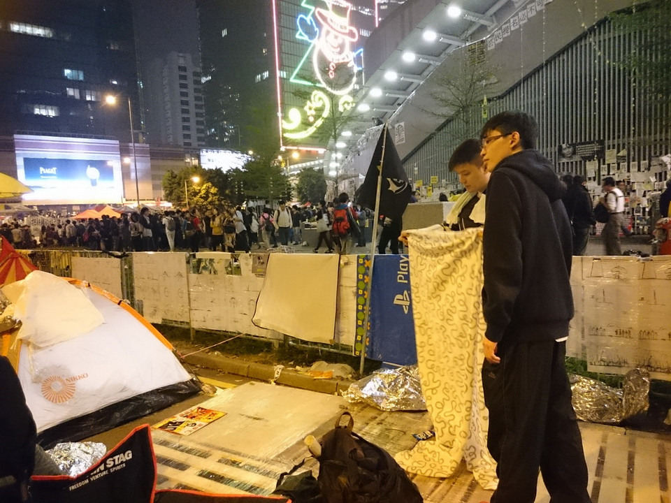 Người biểu tình "Chiếm Trung tâm" ở Admiralty, Hong Kong (Trung Quốc) tiến hành thu dọn đồ dùng cá nhân vào đêm 10/12 trước khi hoạt động giải tỏa đường phố bắt đầu vào sáng hôm sau. (Ảnh: Hà Ngọc)