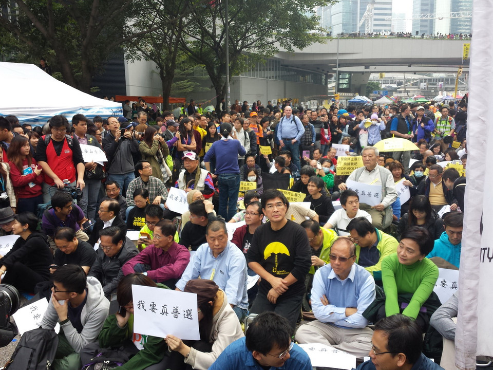 Một số thành viên Hội đồng Lập pháp Hong Kong (Trung Quốc) và người biểu tình ngồi trên đường Harcourt ở Admiralty vào sáng 11/12. (Ảnh: Hà Ngọc)