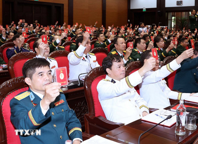 Các đại biểu biểu quyết thông qua Nghị quyết Đại hội. (Ảnh: Thống Nhất/TTXVN) ttxvn-be-mac-dai-hoi-dang-bo-quan-doi.jpg